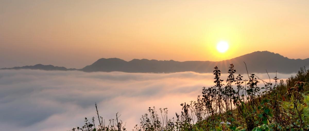 Sonnenaufgang über einer nebeligen Berglandschaft