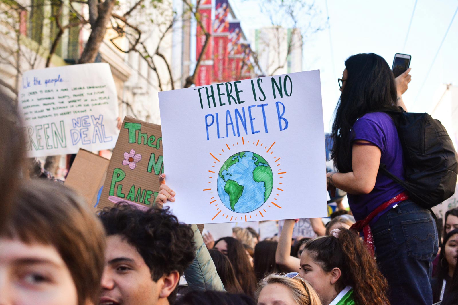 Demonstrierende Menschen halten Schild mit Slogan There is no Planet B